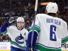 Brock Boeser des Canucks de Vancouver célèbre son but avec Quinn Hughes pour prendre une avance de 1-0, lors de la première période au Crypto.com Arena le 18 mars 2023 à Los Angeles.