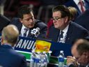 Le directeur du dépistage des Canucks de Vancouver, Judd Brackett, s'entretient avec le directeur général Jim Benning lors de la deuxième journée du repêchage 2019 de la LNH au Rogers Arena de Vancouver, en Colombie-Britannique, le samedi 22 juin 2019.