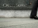 Un piéton passe devant un logo du Credit Suisse à l'extérieur de son immeuble de bureaux à Hong Kong, Chine.