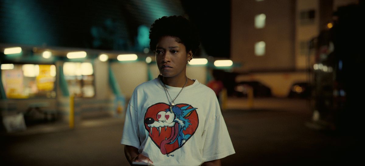 Emerald (Keke Palmer) portant un T-shirt graphique blanc la nuit dans Nope