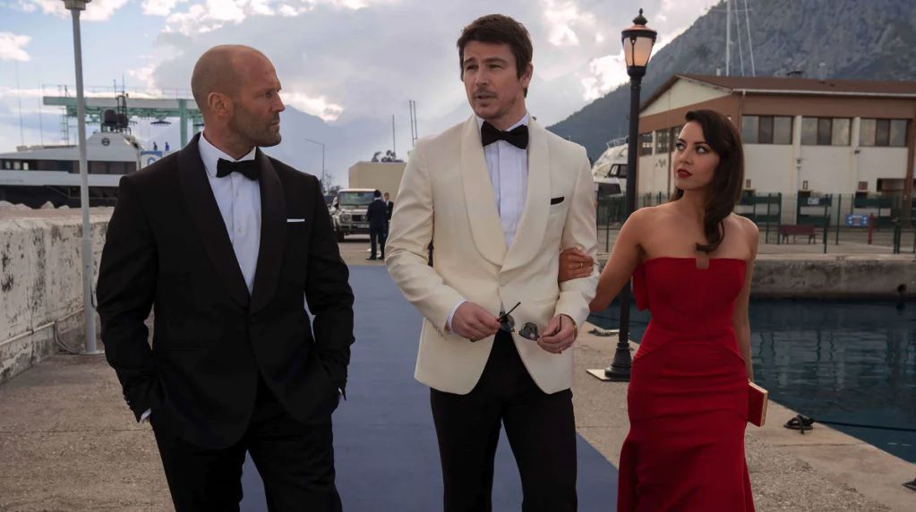 Jason Statham, Josh Hartnett et Aubrey Plaza marchent le long d'une jetée portant de très beaux vêtements dans Operation Fortune : Ruse de guerre.