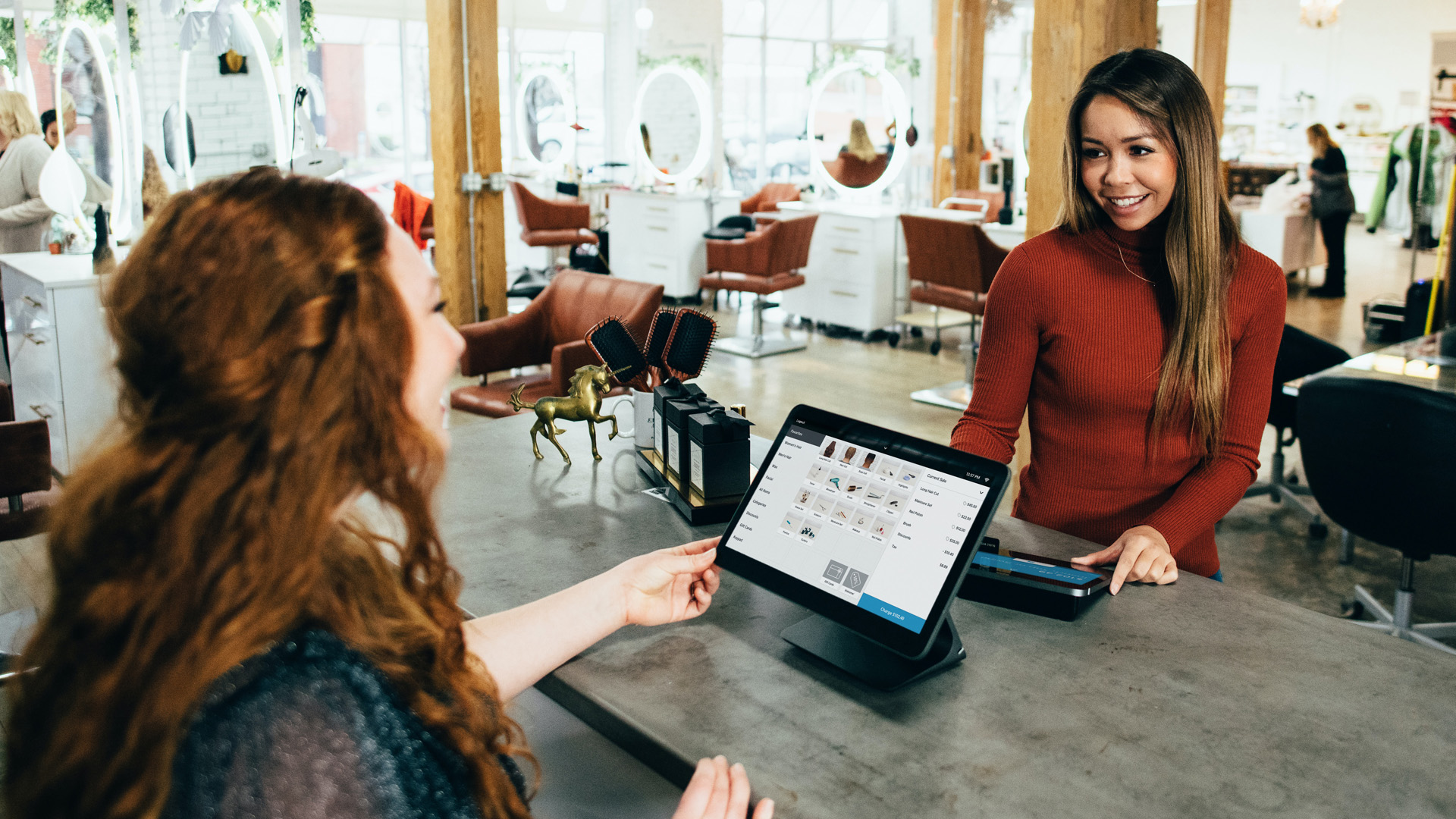 femme payant un service dans un salon à l'aide d'un système pos