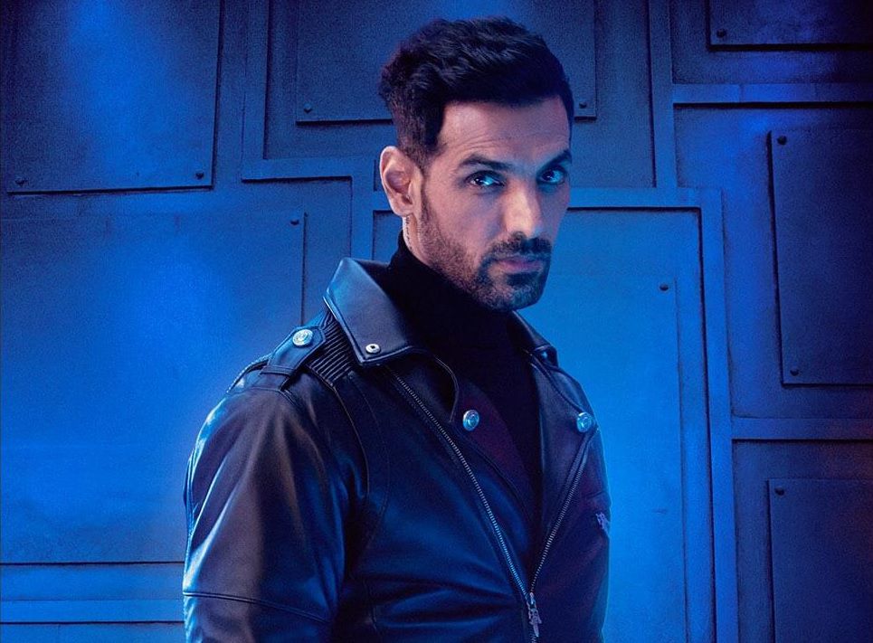 John Abraham comme Jim dans Pathaan, vêtu d'une veste en cuir sur fond bleu