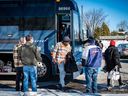 Des migrants sortent d'un bus à Plattsburgh, New York, où des chauffeurs de taxi les attendent pour les emmener à la frontière canadienne à Roxham Road.