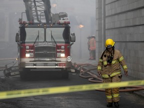 Des pompiers de Montréal sur les lieux d'un incendie sur la rue du Port dans le Vieux-Montréal le 16 mars 2023.