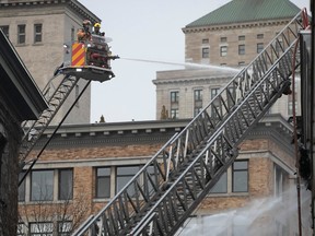 Des pompiers de Montréal sur les lieux d'un incendie sur la rue du Port dans le Vieux-Montréal le 16 mars 2023.