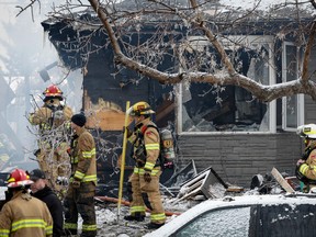 Des pompiers se rendent sur les lieux d'une explosion dans une maison qui a blessé plusieurs personnes, détruit une maison et endommagé d'autres à Calgary, en Alberta, le lundi 27 mars 2023.