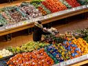 Une personne pousse un caddie dans la section des produits d'une épicerie à Toronto, le 22 novembre 2022. 