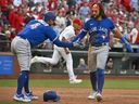 L'arrêt-court des Blue Jays Bo Bichette (11) et le voltigeur droit George Springer (4) célèbrent après avoir marqué contre les Cardinals de St. Louis lors de la huitième manche au Busch Stadium. 