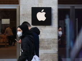 Les acheteurs passent devant un magasin Apple Inc. à Berlin, en Allemagne.