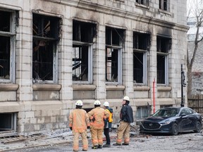 Des enquêteurs et des pompiers sont montrés sur les lieux à la suite d'un incendie dans le Vieux-Montréal le samedi 18 mars 2023, qui a ravagé l'édifice patrimonial.  L'incendie a causé des dommages structurels à l'édifice patrimonial et il est trop dangereux pour les enquêteurs de chercher des victimes, alors dimanche matin, des équipes seront amenées pour démonter la façade des deuxième et troisième étages de l'édifice, construit en 1891.