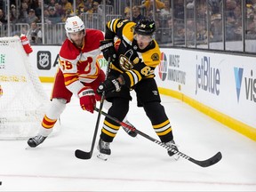 Brad Marchand des Bruins de Boston patine contre Noah Hanifin des Flames de Calgary lors de la première période au TD Garden le 10 novembre 2022 à Boston, Massachusetts.  Les Bruins ont gagné 3-1.