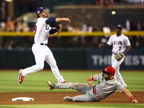 13 mars 2023 ;  Phoenix, Arizona, États-Unis ;  Le joueur de troisième but américain Nolan Arenado (à gauche) se lance à la première base pour terminer le double jeu après avoir forcé le coureur de base canadien coulissant Edouard Julien dans la sixième manche lors de la Classique mondiale de baseball à Chase Field.