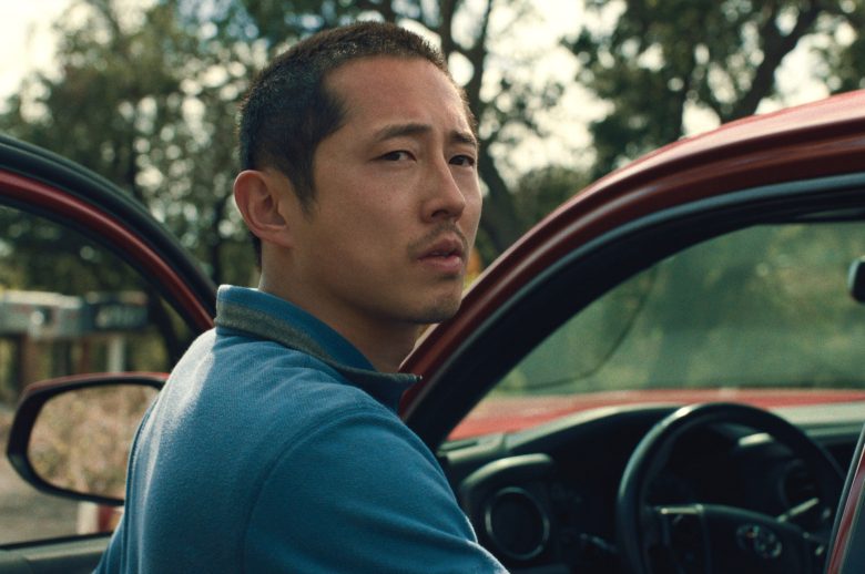 Medium shot of a man about to enter the driver's seat of a large red vehicle; still from "Beef"