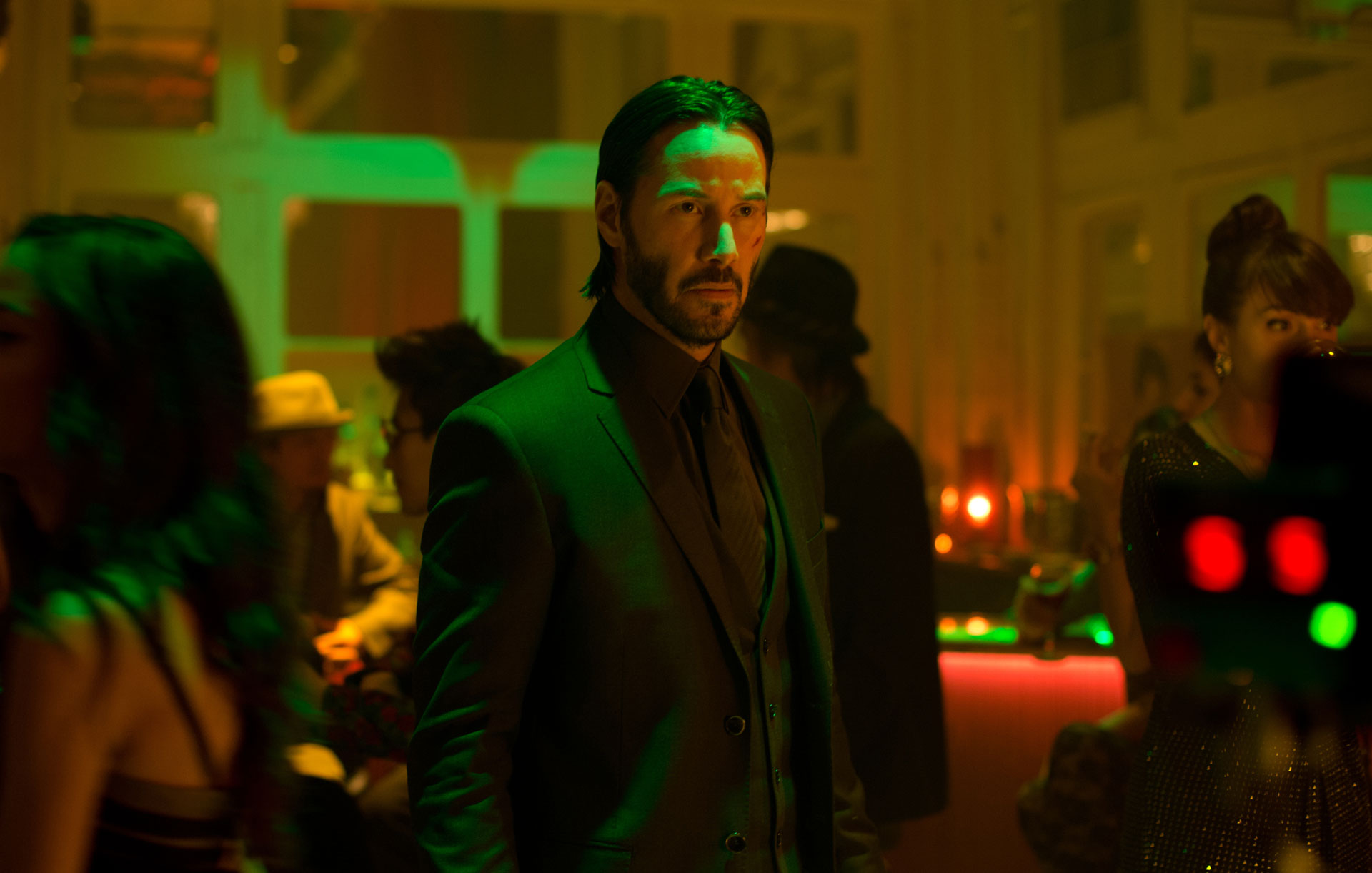 Keanu Reeves dans le rôle de John Wick, debout dans une boîte de nuit, dans John Wick