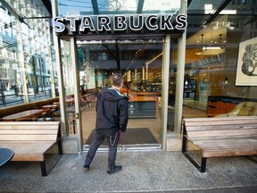 Sean Stubbs regarde à la fenêtre d'un Starbucks fermé après qu'un homme a été poignardé à mort dimanche en fin d'après-midi.