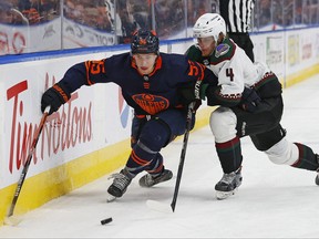 7 décembre 2022 ;  Edmonton, Alberta, CAN ;  L'attaquant des Oilers d'Edmonton Dylan Holloway (55) et le défenseur des Coyotes de l'Arizona Juuso Valimako (4) se battent le long de la bande pour une rondelle libre au cours de la troisième période à Rogers Place.