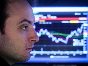 Un trader spécialisé travaille à l'intérieur d'un stand sur le sol de la Bourse de New York.