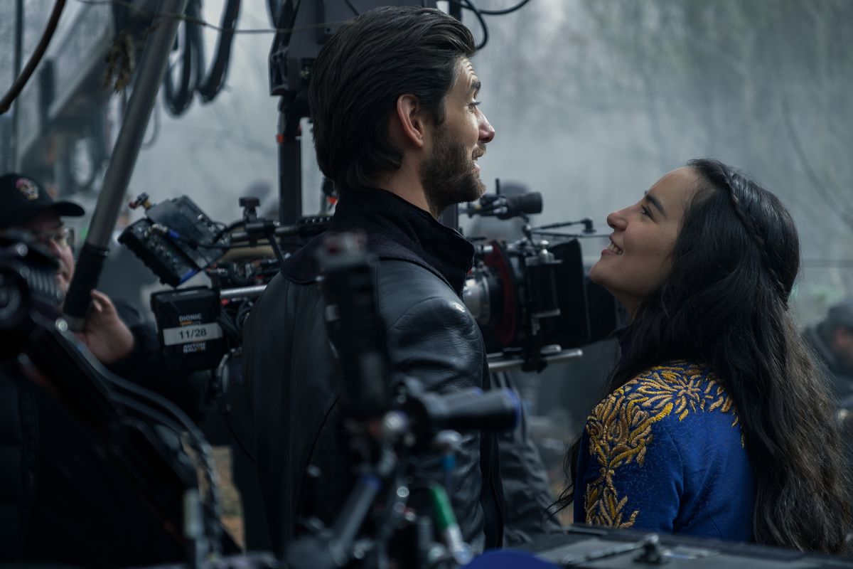 une photo des coulisses de Ben Barnes et Jessie Mei Li, tous deux en costume et rigolant