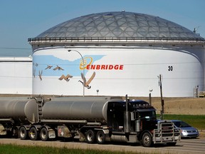 Un réservoir de stockage se dresse au-dessus d'une autoroute au terminal d'Enbridge Inc. à Edmonton, en Alberta.