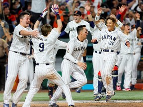 20 mars 2023 ;  Miami, Floride, États-Unis ;  Le joueur de premier but japonais Kazuma Okamoto (au centre) réagit avec ses coéquipiers après avoir remporté le match contre le Mexique au LoanDepot Park.