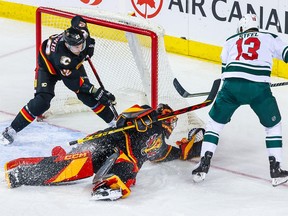 Le gardien des Flames de Calgary Jacob Markstrom (25 ans) effectue un arrêt contre le centre du Wild du Minnesota Sam Steel (13 ans) lors de la première période au Scotiabank Saddledome le samedi 4 mars 2023.