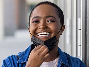 Une femme abaisse son masque facial.