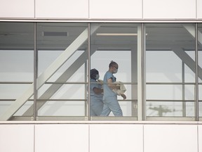 Des travailleurs de la santé traversent un pont aérien dans un hôpital de Montréal.