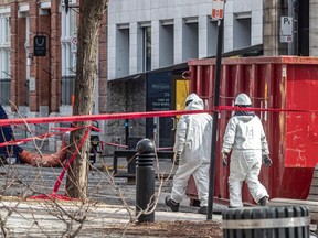 Des employés de Montréal en tenue de protection contre les matières dangereuses ont aidé à la collecte d'ADN lorsque des corps ont été retirés des décombres d'un incendie dans le Vieux-Montréal.