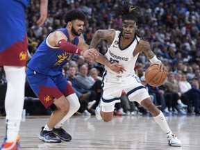 Le garde des Memphis Grizzlies Ja Morant, à droite, affronte le garde des Denver Nuggets Jamal Murray lors de la seconde moitié d'un match de basket de la NBA le vendredi 3 mars 2023 à Denver.