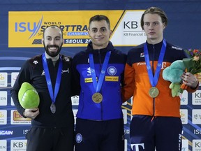 Le médaillé d'or Pietro Sighel d'Italie, au centre, pose avec le médaillé d'argent Steven Dubois du Canada, à gauche, et le médaillé de bronze Jens van 'T wout, à droite, des Pays-Bas lors de la cérémonie de remise des prix du 500 mètres masculin à l'ISU World Short Track Championnats de patinage de vitesse à Séoul, Corée du Sud, samedi 11 mars 2023.