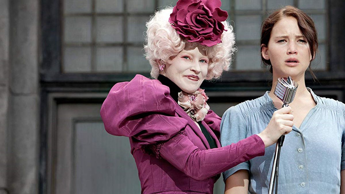 Effie (Elizabeth Banks) tend un micro à Katniss (Jennifer Lawrence)