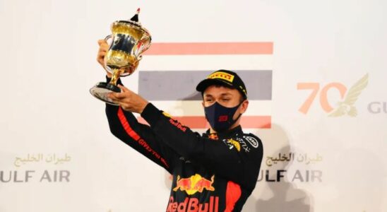 Alex Albon holding a podium trophy.