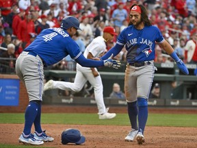 L'arrêt-court des Blue Jays Bo Bichette (11) et le voltigeur droit George Springer (4) célèbrent après avoir marqué contre les Cardinals de St. Louis lors de la huitième manche au Busch Stadium.