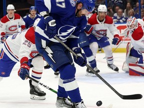 L'attaquant du Lightning de Tampa Bay Alex Killorn tente de contrôler la rondelle alors qu'il est mis en échec par Denis Gurianov des Canadiens lors de la première période samedi soir à l'Amalie Arena.