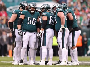 Isaac Seumalo # 56, Jason Kelce (62 ans) et Landon Dickerson (69 ans) des Eagles de Philadelphie se blottissent avec leurs coéquipiers contre les 49ers de San Francisco lors du premier quart du match de championnat NFC au Lincoln Financial Field le 29 janvier 2023 à Philadelphie , Pa.