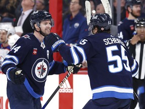 Josh Morrissey (à gauche) célèbre son but gagnant avec le centre Mark Scheifele lors de la victoire 7-5 des Jets sur les Oilers d'Edmonton samedi soir.