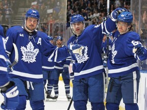 L'attaquant des Maple Leafs William Nylander, à droite, célèbre un but contre les Oilers avec ses coéquipiers Austin Matthews, à gauche, et Mark Giordano, au centre, lors d'un match de la LNH au Scotiabank Arena de Toronto, le samedi 11 mars 2023.