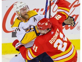 L'attaquant des Flames de Calgary Kevin Rooney et le défenseur des Predators de Nashville Mattias Ekholm entrent en collision lors d'un match de la LNH au Scotiabank Saddledome de Calgary le 3 novembre 2022.