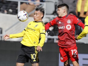 Le milieu de terrain de Columbus Crew Lucas Zelarayán, à gauche, protège le ballon alors que le défenseur du Toronto FC Kadin Chung défend pendant la seconde moitié d'un match de football MLS le samedi 12 mars 2022 à Columbus, Ohio.