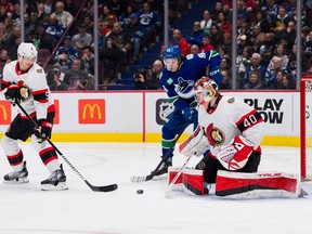 Le défenseur des Sénateurs d'Ottawa Nick Holden (5) regarde le gardien Mads Sogaard (40) faire un arrêt sur l'attaquant des Canucks de Vancouver Andrei Kuzmenko (96) en troisième période au Rogers Arena.