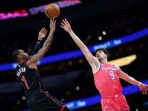 Will Barton des Raptors (à gauche) tire le ballon alors que Deni Avdija des Wizards défend au deuxième quart à Capital One Arena le jeudi 3 mars 2023.