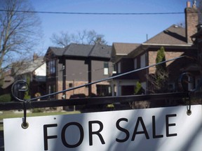 Un panneau vendu est affiché devant les maisons de l'ouest de Toronto le dimanche 9 avril 2017.