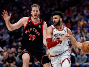 Le garde des Nuggets Jamal Murray (à droite) contrôle le ballon devant le centre des Raptors Jakob Poeltl (à gauche) lors de l'action NBA du deuxième trimestre au Ball Arena de Denver, le lundi 6 mars 2023.