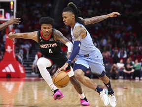 Le garde des Memphis Grizzlies Ja Morant (12) dribble le ballon tandis que le garde des Houston Rockets Jalen Green (4) défend au Toyota Center.