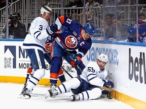 Justin Holl et Mark Giordano des Maple Leafs de Toronto défendent contre Anders Lee des Islanders de New York lors de la deuxième période à l'UBS Arena le 21 mars 2023 à Elmont, New York.