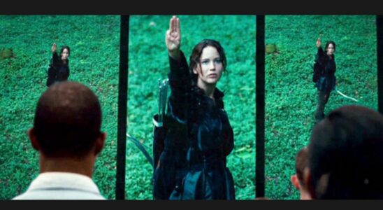 Jennifer Lawrence as Katniss doing three finger salute in The Hunger Games