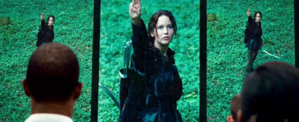 Jennifer Lawrence as Katniss doing three finger salute in The Hunger Games