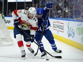 27 mars 2022 ;  Toronto, Ontario, CAN ;  L'attaquant des Panthers de la Floride Carter Verhaeghe (23 ans) et le défenseur des Maple Leafs de Toronto Timothy Liljegren (37 ans) se battent pour la rondelle au cours de la deuxième période au Scotiabank Arena.