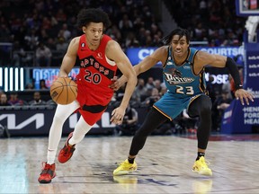 25 février 2023 ;  Detroit, Michigan, USA;Toronto Raptors guard Jeff Dowtin Jr. (20) dribble sur Detroit Pistons guard Jaden Ivey (23) au premier semestre à Little Caesars Arena.